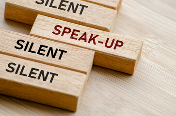 Silent, speak up, and silent again message on blocks, illustrating the tension between voicing out...