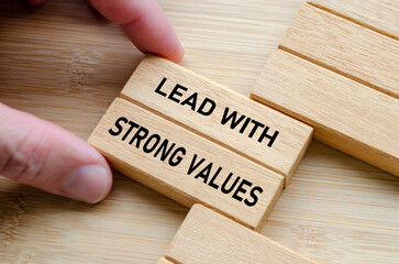 Lead with strong values phrase on stacked wooden blocks, emphasizing the importance of integrity,...