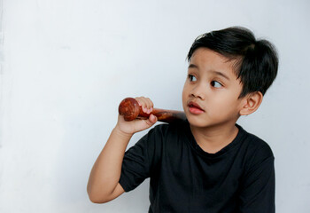 Boy Holding Baseball Bat Over Shoulder Looking Away