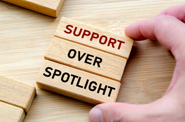 Support over spotlight wording on cubes, reminding leaders to boost their team performance quietly...