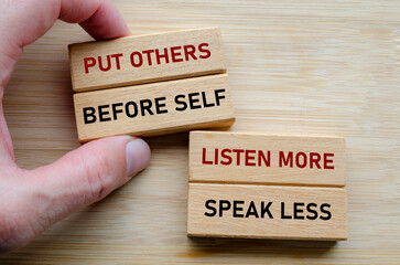 Put others before self message on wood cubes, highlighting a servant leadership mindset where...