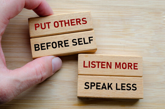 Put others before self message on wood cubes, highlighting a servant leadership mindset where empathy and humility come first