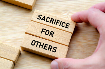 Sacrifice for others phrase on wooden blocks, leadership expectation and respect concept
