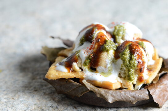 North Indian street food bhalla papdi dahi chaat &ndash; crispy papdi, soft dahi bhalla, sweet curd, chutneys, vibrant cold snack served in plate