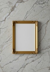 A simple golden picture frame with ornate corners, empty and resting on a marble surface.