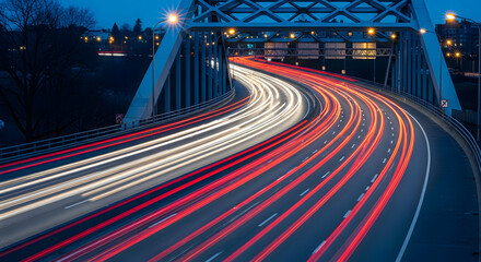 Obraz premium Nighttime City Bridge with Moving Car Light Trails on Curved Road