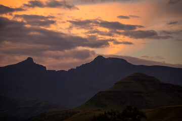 Spectacular ink and purple sunset in the Drakensberg Mountains, South Africa, with the bowl shaped formed by the two peaks of Hodgin’s Peak, known as Giant’s Cup towering in the background.