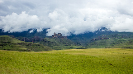 Dramatic view of the Drakensberg mountains with the high jagged peaks shrouded by the gathering clouds.