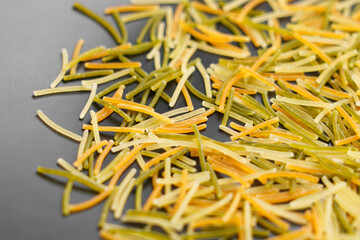 Uncooked small colored vermicelli on a plate. Macro shot