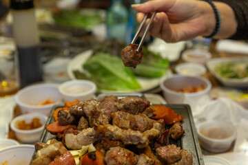 A Delicious Korean BBQ Platter with Grilled Meat and Vegetables Served on a Hot Plate, Surrounded by Side Dishes
