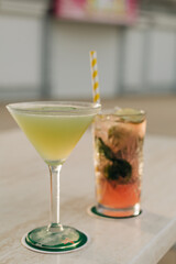 Fresh cocktail drinks served on a table at a vibrant outdoor bar during sunset