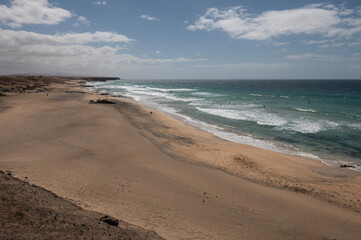 Vista panorámica de Piedra Playa con surfistas en el mar, en El Cotillo, Fuerteventura