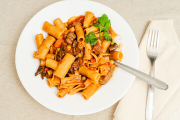 Delicious beef stew with rigatoni pasta, vegetables, and parsley garnish