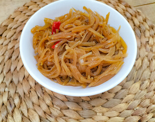 Selective focus. Stir-fried young papaya slices tastes spacy and delicious. Papaya fruit is cooked...