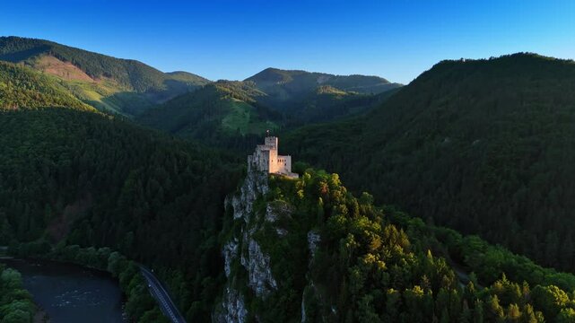 Beautiful castle located on the mountain top over the river. Mighty verdant mountains at backdrop. Strecno Castle, northern Slovakia. Aerial view.
