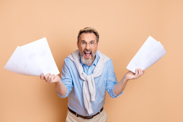Elderly businessman holding documents while expressing emotions against a cream-toned background