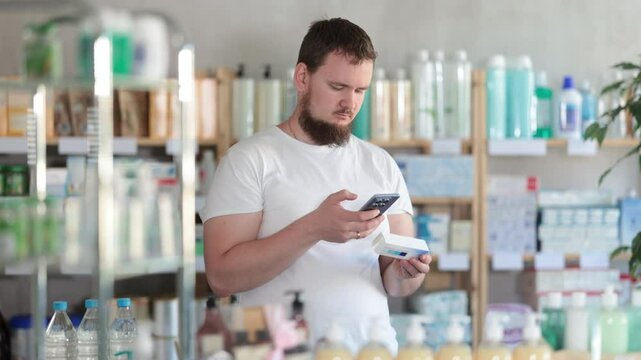 Young man buyer scanning qr code for box of ointment in pharmacy