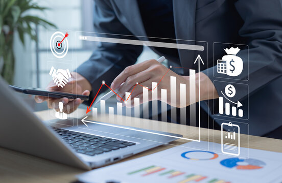 Businessman using laptop to display cost reduction graph. Concept of cost control, budgeting, profit maximization, and financial planning by calculating company income and expenses.