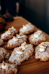 Freshly baked croissants with almond flakes in bakery display window.