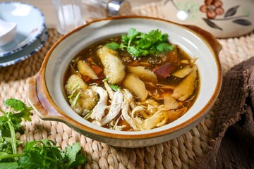 fish maw soup in a white bowl on grey background	