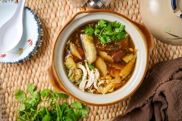 fish maw soup in a white bowl on grey background	