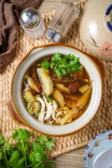 fish maw soup in a white bowl on grey background	