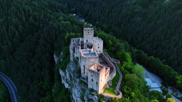 Approaching the reconstruction of medieval castle Strecno in northern Slovakia. Drone footage over the site. Wooded verdant mountains around the castle.