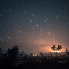Starry night, meteor shower over rural landscape