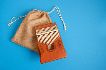 wooden kalimba on blue background, traditional african musical instrument, meditation instrument top view copy space