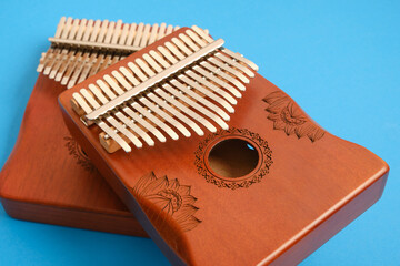 wooden kalimba on blue background, traditional african musical instrument, meditation instrument