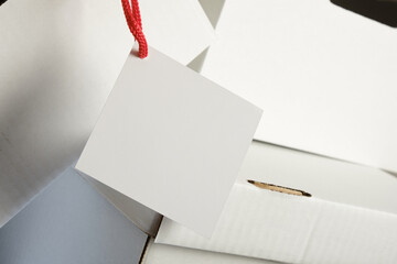 tag and pile of white cardboard boxes with slots for holding, storage boxes