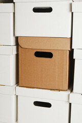one brown box and a pile of white cardboard boxes with slots for holding, storage boxes, wall of boxes, mock up