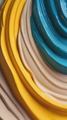 Close-up of glossy swirled paint layers in yellow, beige, and teal tones. Concept of abstract color composition, artistic texture, and design flow