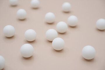Scattered white spheres on a smooth beige surface