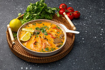 Tom yum soup with shrimp, sea food and lime on table