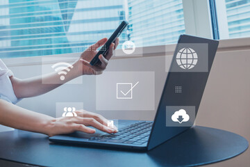 スマホとノートパソコンを操作する女性、ビジネスシーン、スマホで検索するイメージ、ネットワーク © Metro Hopper