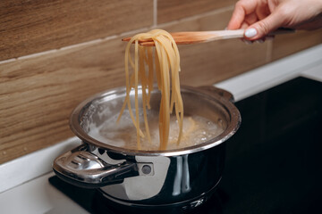 Step by step the process of cooking Italian pasta carbonara in spaghetti, add sauce with fried...