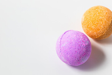 Vibrant bath bombs in shades of purple and orange resting on a clean surface