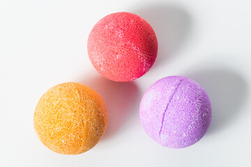 Colorful bath bombs arranged in a playful manner on a white background