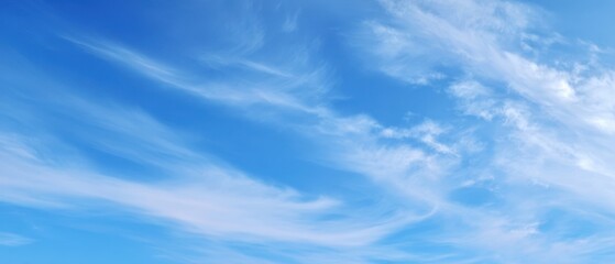 The serene beauty of a clear blue sky with wispy clouds
