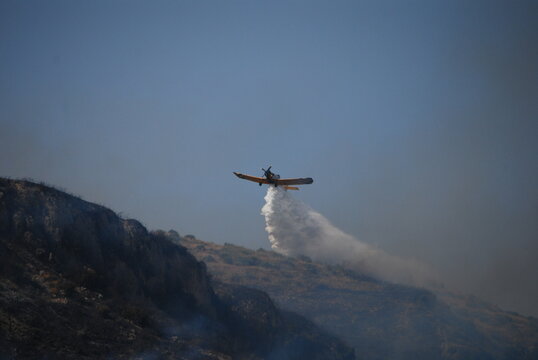 Plane dropping water on wildfire