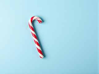 Striped candy stick on a blue background. Top view. Copy space.
