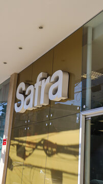 Fachada de ag&ecirc;ncia do Banco Safra no Brasil. Logotipo dourado em pr&eacute;dio moderno, captado em &aacute;rea urbana com identidade visual corporativa. Mogi das Cruzes SP em 06 julho 25