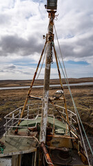 Ship Mast in Icelandic Landscape The top structure of an old Icelandic fishing boat contrasts with the flat, open landscape in the background.  © Sebastian
