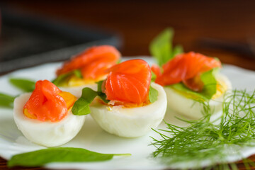 Decorated eggs with red fish and herbs on the table