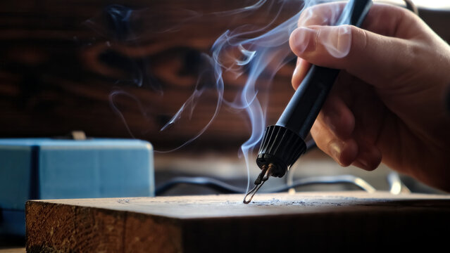 Burn out the picture. Woodburning or pyrography. An artist drawing on a wooden plank with pyrograph. Wood burning ASMR creative hobby. Art class workshop. Creative activity. High quality 4k footage.
