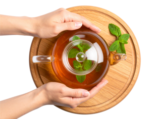 Top View of Herbal Tea in Glass Teapot with Hand and Window Reflection