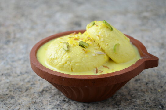 Delicate Indian dessert ras malai &ndash; soft chenna (paneer) discs soaked in saffron and cardamom-flavored sweetened milk, garnished with dry fruits &ndash; served chilled in bowl
