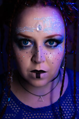 Futuristic woman with bold makeup, glowing blue eyes, circuit patterns on her face, braided hair...