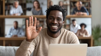 Online meeting participant waving to video conference attendees, smiling cheerfully from home, with people visible in the background video call display.